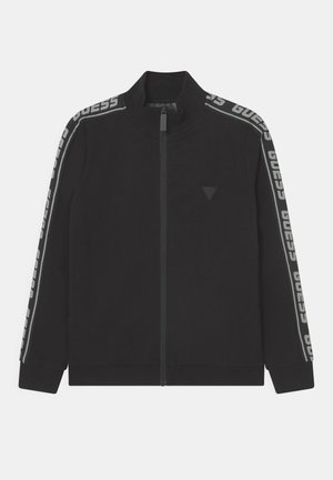 Giacca nera con zip realizzata in tessuto liscio, con colletto alto, maniche lunghe e branding grigio a contrasto lungo le spalle.