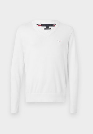 Maglione bianco a scollo a V realizzato in tessuto morbido. Presenta maniche lunghe, polsini e orlo a coste. Piccolo patch con logo sul lato sinistro del petto.