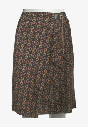 Jupe portefeuille noire avec un motif répétitif abstrait de maillons de chaîne marron et orange, sécurisée par un œillet et un détail chaîne à la taille.