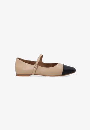 Beige leren platte schoen met een zwarte neus, voorzien van een enkele verstelbare band over de wreef en een platte zool.