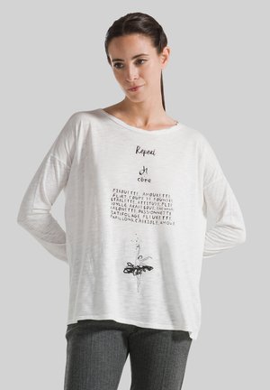 Weißes Langarmshirt mit Text und einer schwarzen Ballerina-Grafik am unteren Ende. Weiches, leichtes Material mit lässiger Passform.