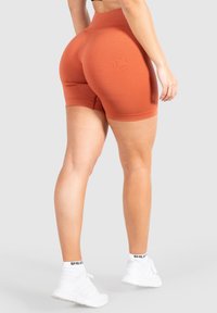 Hoge taille, roestkleurige biker shorts gemaakt van rekbaar materiaal, met een gladde textuur en een aansluitend ontwerp. Aangevuld met een geribde tailleband.