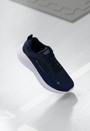 Granatowe buty sportowe z gładką syntetyczną cholewką, białą teksturowaną podeszwą, systemem sznurowania oraz logo "Champion" na boku.