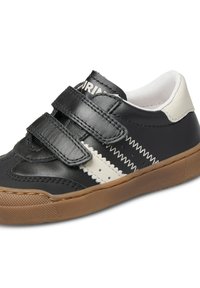 Sneaker in pelle bianca e nera con due cinturini in velcro, un motivo zigzag cucito e una suola in gomma marrone.