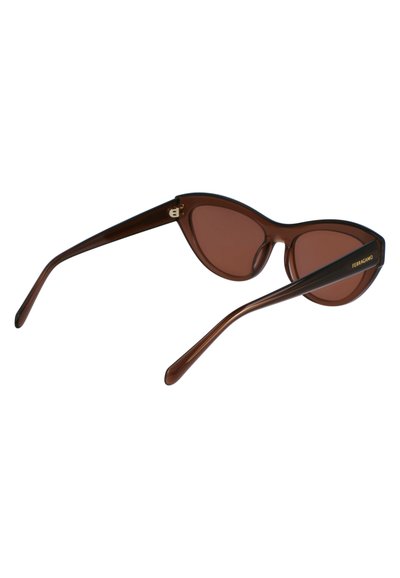 Brown cat-eye sunglasses with a glossy finish, accented by a gold logo on the temple. Slim arms taper to a rounded tip.