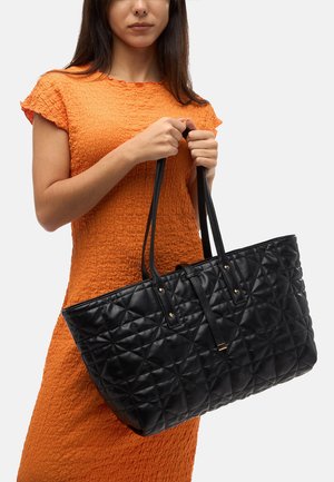 Sort quotet mulepose lavet af syntetisk materiale, med to lange håndtag, en struktureret form og detaljer i guldtonet metal.