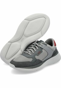 Graue Sportchuhe aus Mesh und Wildleder, mit einer weißen Gummisohle, grauen Schnürsenkeln und roten Akzenten an der Ferse.