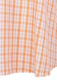 Tissu à carreaux orange et blanc présentant un motif en grille avec des lignes fines, fabriqué en matériau lisse et léger, adapté pour les vêtements ou les accessoires.