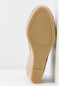 Semelle de chaussure à talon compensé beige avec semelle en caoutchouc, côtés tissés, taille 37 et texte visible "Made in Spain".