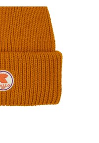 Beanie lavorato a maglia arancione con una consistenza a costine spesse, dotato di una toppa circolare con un logo di un orso e testo. Orlo arrotolato in fondo.