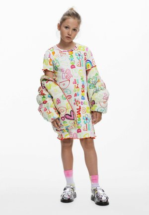 Rochie scurtă colorată cu text și grafice jucăușe, asortată cu o jachetă căptușită. Are un decolteu rotund și tiv cu volane. Sandale argintii.