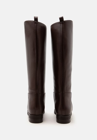 Paire de bottes hautes en cuir marron foncé vues de dos avec une texture lisse et des languettes en haut.
