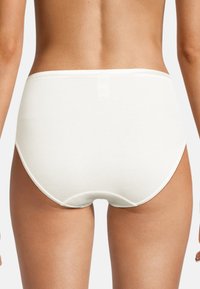 Mutande hipster bianche in cotone con texture liscia, girovita elastico e bordi senza cuciture, progettate per comfort e uso quotidiano.