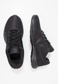 Black athletic shoes with a breathable mesh upper, textured design, lace closure, and cushioned soles for comfort and flexibility.