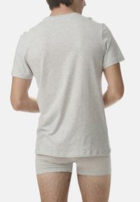Graues Baumwoll-T-Shirt mit kurzen Ärmeln, lockerer Schnitt, getragen mit passenden grauen Boxershorts, von hinten betrachtet.