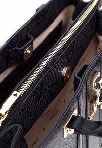 Zwarte handtas met een gestructureerde buitenkant, gouden hardware en een ritssluiting. Het interieur heeft een beige voering en compartimenten voor organisatie.