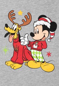 Topolino e Pluto sono illustrati su uno sfondo grigio. Topolino indossa un maglione rosso con un pupazzo di neve, mentre Pluto ha le corna e un maglione rosso.