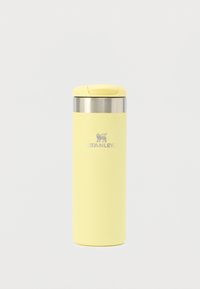 Gele geïsoleerde reismok van roestvrij staal met een ronde vorm, een gestructureerde matte afwerking en een zilveren deksel. Voorzien van het STANLEY-logo.