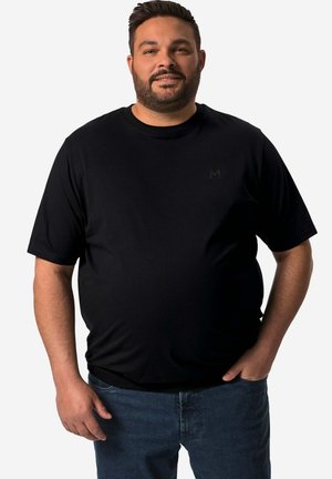Schwarzes Kurzarm-T-Shirt mit Rundhalsausschnitt, aus weichem Stoff gefertigt, mit einem dezenten, tonalen Logo auf der Brust, kombiniert mit blauen Jeans.