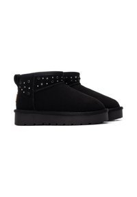 Botines de ante negros con detalles de tachas alrededor del cuello, suela de goma plana y diseño de punta redonda.