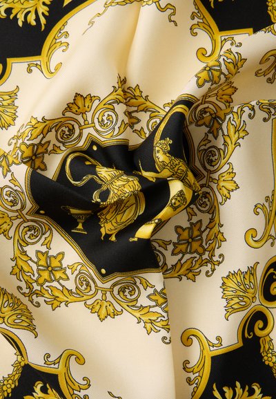 Μεταξωτό ύφασμα με περίπλοκα χρυσομαύρα μπαρόκ σχέδια που περιλαμβάνουν ανθικά μοτίβα και κλασικές φιγούρες σε κρεμ φόντο, ελαφρώς τσαλακωμένο.