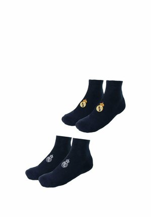 Dwie pary czarnych skarpetek do kostki z herbem klubu piłkarskiego Real Madryt, jedna para ze złotym logo, druga z białym logo.