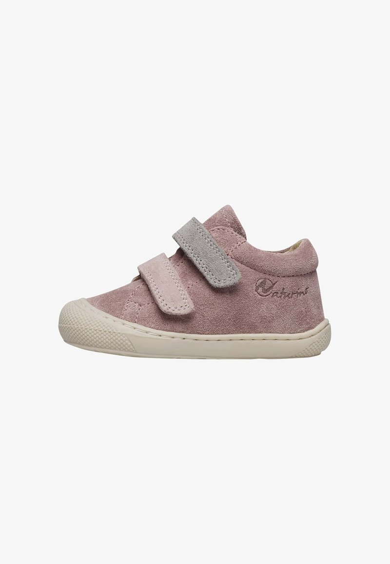 Chaussure en daim rose clair pour tout-petits avec des bandes Velcro grises, bout arrondi, semelle en caoutchouc blanc et détails texturés sur l'empeigne et la semelle.
