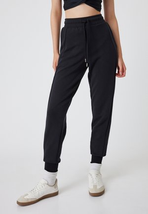 Zwarte joggers met een elastische tailleband, trekkoord en zijzakken. Kenmerkt zich door ribgebreide boorden en een gladde, zachte textuur.