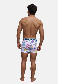 Slip da uomo colorati con motivo a griglia e forme astratte in rosa, blu e giallo; vita elastica con testo.