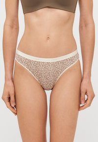 Leopárdmintás bikini alsó, bézs alapszínnel és barna foltokkal, puha, rugalmas derékpánttal. Könnyű, félig átlátszó anyag.