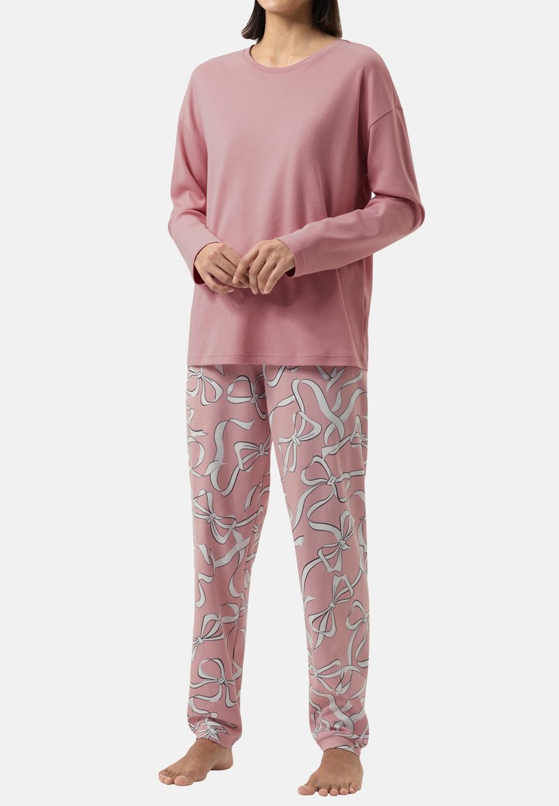 Pink long-sleeve top and matching pajama pants featuring a repeated white bow pattern. Soft fabric, relaxed fit, and ankle-length design.