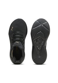 Zapatillas deportivas negras con un upper de malla texturizada, cordones planos y una suela de goma con patrón. Los acentos incluyen un pequeño logo en dorado.