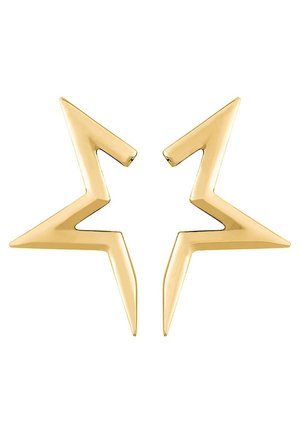 Boucles d'oreilles en métal doré en forme d'étoiles abstraites et angulaires aux bords en zigzag tranchants, présentées sur fond blanc.