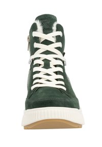 Baskets montantes en suede vert avec des lacets blancs et une semelle en caoutchouc texturée. Présente une fermeture éclair sur le côté et des accents en fourrure synthétique sur le col.