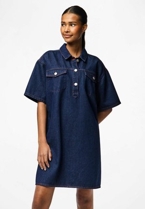 Robe chemise en denim bleu foncé avec des manches courtes, col boutonné, poches poitrine et détails de surpiqûres contrastantes.