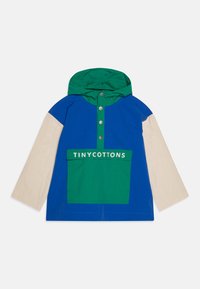 Pull à blocs de couleur avec un corps bleu, une capuche verte et des manches crème. Dispose d'une poche avant avec "TINY COTTONS" imprimé en blanc.