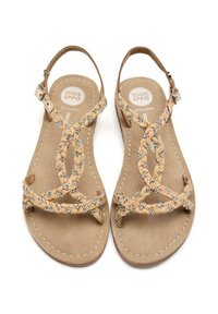 Sandalias de cuero marrón con tiras trenzadas adornadas con pequeños acentos plateados. Suela plana y diseño de cinturón ajustable en el tobillo.