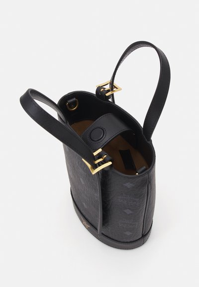 Sac seau en cuir noir avec quincaillerie dorée, extérieur texturé et poche intérieure. Base arrondie, double poignées et motif visible.