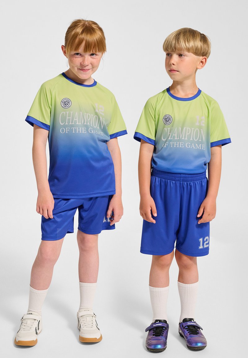 Blå och grön gradient fotbollsjersey med texten "CHAMPION OF THE GAME" och nummer 12; blå shorts; lager av strumpor; atletiska skor.