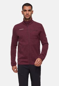 Giacca in fleece bordeaux con zip, colletto alto, 2 tasche laterali e una tasca sul petto. Logo sul petto, tessuto texture.