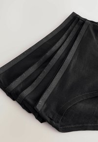 Mustat puuvillabikinit järjestettyinä pinoon, joissa on sileä pinta ja litteä joustovyötärö, jossa on kohokuvioitu teksti.