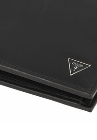 Portafoglio in pelle nera con una texture liscia, dotato di una piastra logo triangolare in argento e cuciture ordinate lungo i bordi.