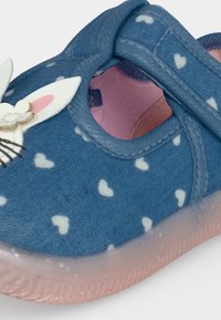 Chaussure pour enfant bleue avec motif de cœurs blancs, doublure rose, bride velcro et visage de lapin décoratif à l’avant.