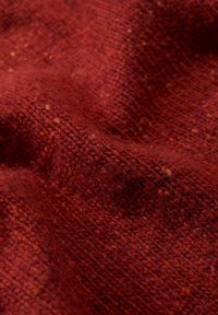 Prim-plan al unui material textil împletit, gros, de culoare roșu închis, cu fibre vizibile și ușoare variații de nuanță.