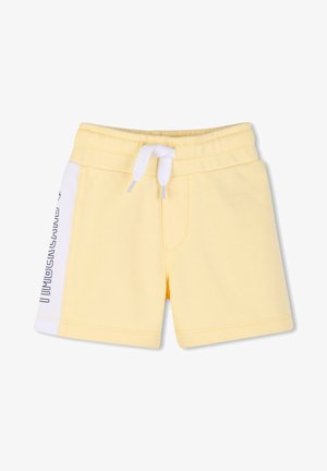 Shorts jaunes pour tout-petit avec panneaux latéraux blancs, taille élastique et cordon blanc, avec texte de marque noir sur le panneau latéral gauche.