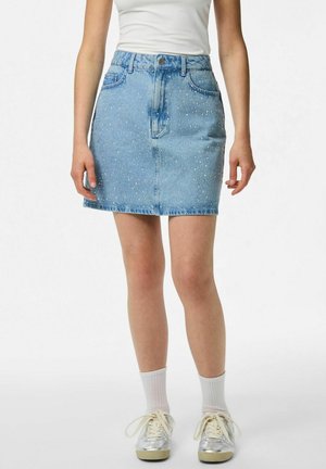 Jupe en denim bleu clair avec une taille cintrée, boutons sur le devant et strass éparpillés sur le tissu. Elle présente un ourlet droit et un design à cinq poches.