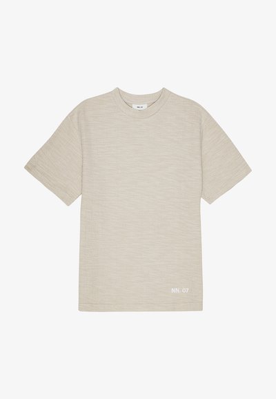 Beige Rundhals-T-Shirt aus strukturiertem Stoff mit kurzen Ärmeln. Mit minimalem weißen Branding unten links.