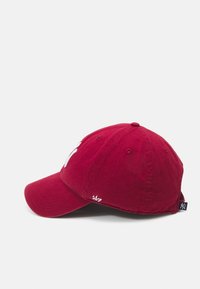 Rode katoen pet met een gebogen rand, geborduurd logo aan de voorkant en luchtgaten voor ventilatie. Bevat een zijtag en een verstelbare band.