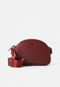 Bordeaux rød skuldertaske lavet af struktureret læder, med en buet form, lynlås, og en matchende stofrem med logodetaljer.