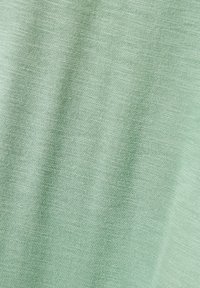 Ljust grönt, texturerat tyg med en subtil, fin väv. Mjuk och slät yta med en lätt glans, idealisk för vardagskläder.
